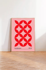 A framed poster with a bold red geometric design featuring a repeating pattern of red circles on a pink background.