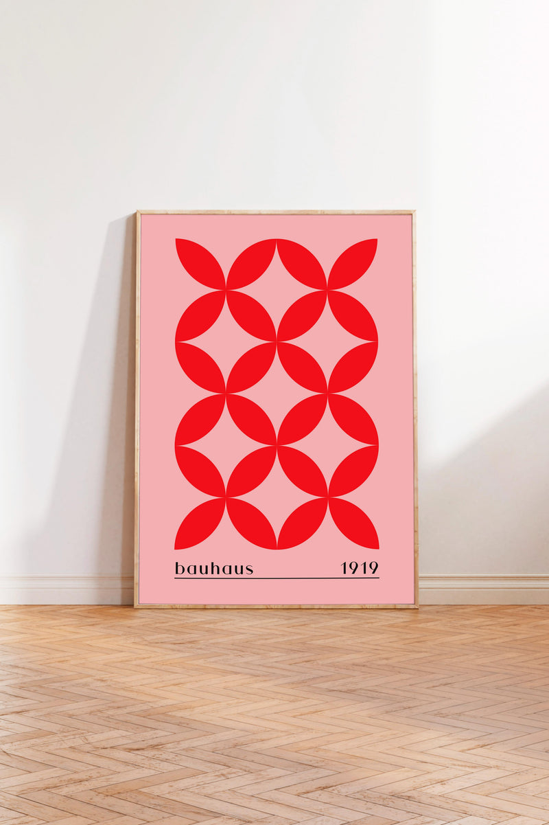 A framed poster with a bold red geometric design featuring a repeating pattern of red circles on a pink background.