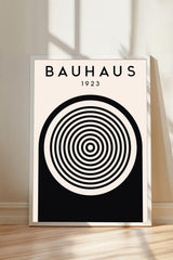 a poster with a minimalist design, featuring a large circular element with concentric circles and the text "BAHAU 23" displayed above it.