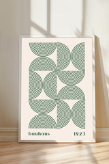 A framed poster with a geometric design featuring concentric circles in shades of green and white.