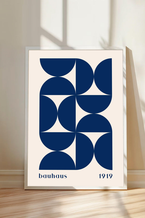 A framed poster with a geometric design in shades of blue and white, featuring the text "bauhaus 1919" at the bottom.