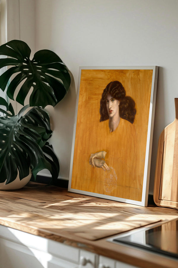 a framed painting of a woman with curly hair, displayed on a wooden surface next to a potted plant.