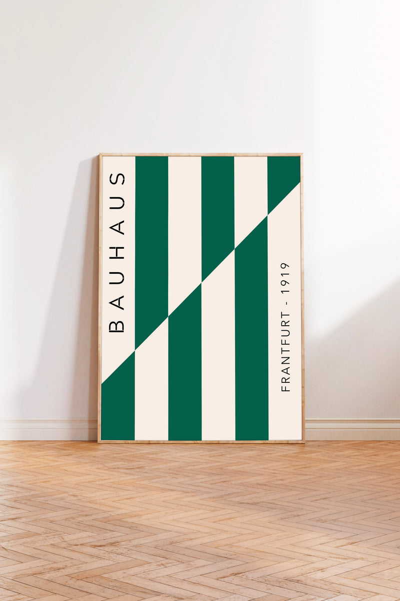 a minimalist poster with a bold geometric design, standing upright on a wooden floor against a white wall.