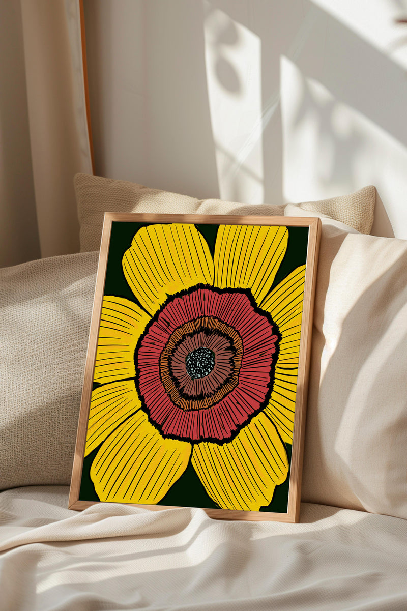 A framed print of a large, vibrant flower with yellow petals and a red center is displayed on a bed with a beige pillow.