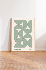 a framed poster with a geometric design in shades of green and white, depicting a pattern of circles and lines.