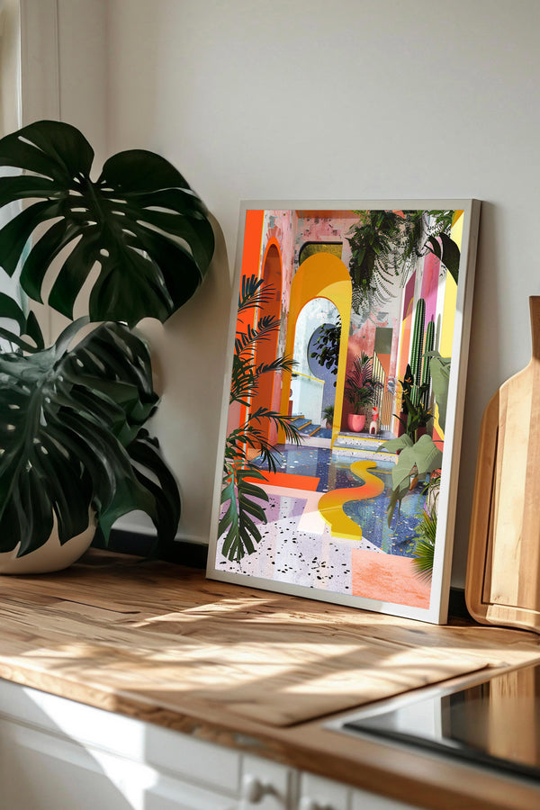 a vibrant, colorful painting of an indoor garden scene, with a variety of tropical plants and flowers. The painting is displayed on a wooden surface, and there is a potted plant to the left of the artwork.