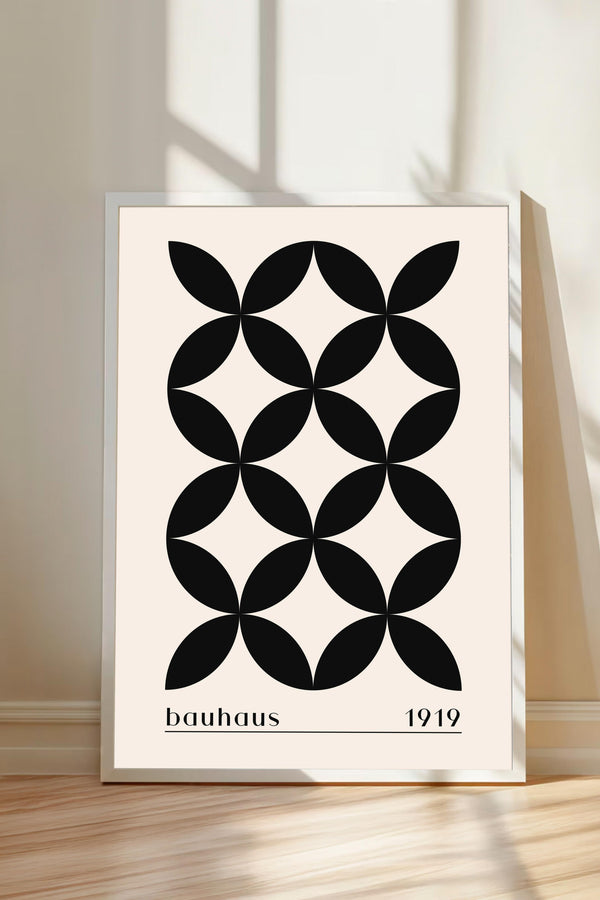 A framed poster with a geometric design featuring a repeating pattern of black circles on a white background.