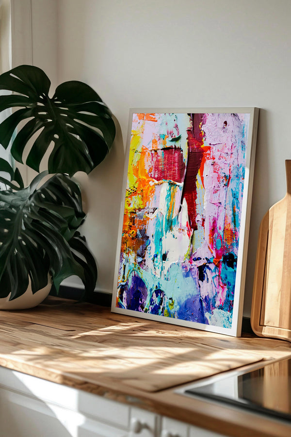 a vibrant, abstract painting displayed on a wooden surface, with a large monstera plant in the background.
