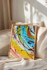 a vibrant abstract painting with bold colors and dynamic brushstrokes, displayed on a bed with a white comforter and a beige pillow.