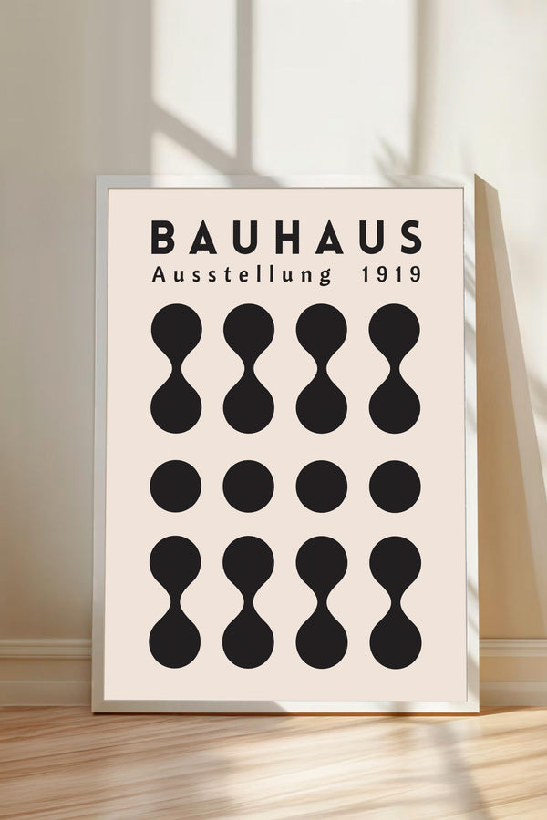 a poster or artwork with the text "BAHAUX" and "AUSTELLLUNG 1919" prominently displayed. The poster is framed and placed on a wooden floor, with a shadow cast on the wall behind it.