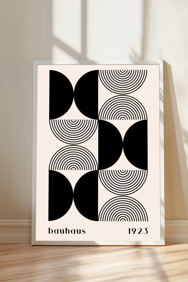 a framed poster with a minimalist geometric design in black and white, depicting a repeating pattern of circles and lines.