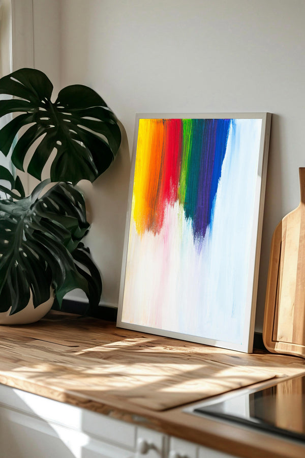a vibrant abstract painting with a rainbow-colored gradient, displayed on a wooden surface. A potted plant is visible in the background, adding a touch of nature to the scene.