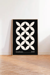 A framed poster with a black and white geometric design featuring a repeating pattern of white circles on a black background.