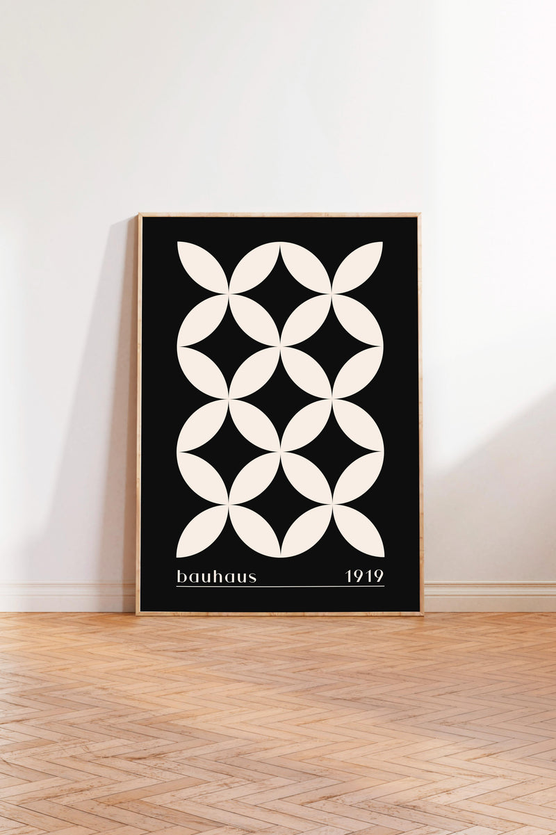 A framed poster with a black and white geometric design featuring a repeating pattern of white circles on a black background.
