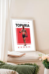 a framed poster of a man, likely a professional fighter, with the title "TOPURIA" prominently displayed.