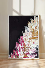 a vibrant abstract painting with a striking contrast of black and white, accented by splashes of pink and white. The painting is framed and displayed on a wooden floor, with a shadow cast on the wall behind it.