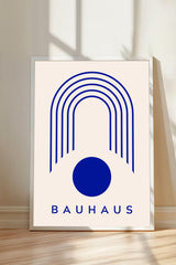 a minimalist poster with a large blue circle and a series of blue lines forming a curved arch shape. The word "BAHAU" is written in blue letters below the arch.