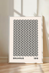 a framed poster with a repeating geometric pattern in black and white.