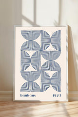 A framed poster with a minimalist design featuring concentric circles in shades of blue and white.