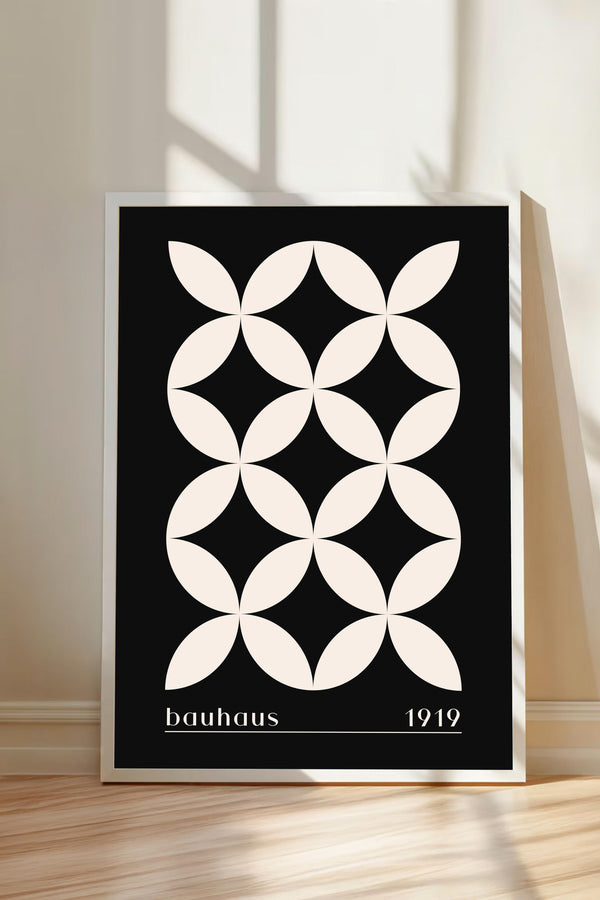 A framed poster with a black and white geometric design featuring a repeating pattern of circles and lines.