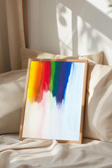 a vibrant painting with a rainbow-colored background, displayed on a bed with a white comforter.