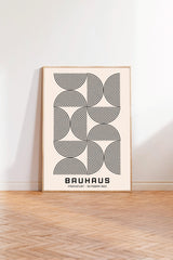 a minimalist poster of Bauhaus, a renowned art school and architect, with a repeating pattern of circles and lines in black and white.