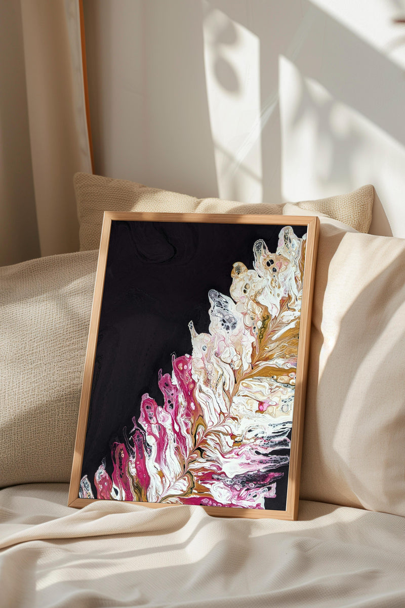 a framed abstract painting with a black background and a vibrant mix of pink and white colors, creating a striking contrast.