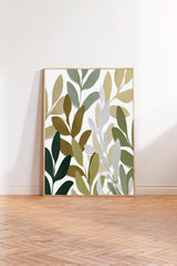 a large, square-shaped painting with a leafy, abstract design in various shades of green and brown. The painting is displayed on a white wall, standing on a wooden floor.